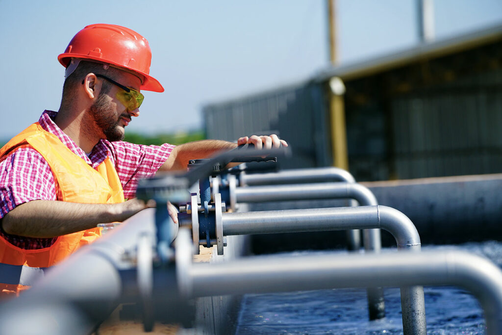 Workman making adjustment to wastewater treatment system