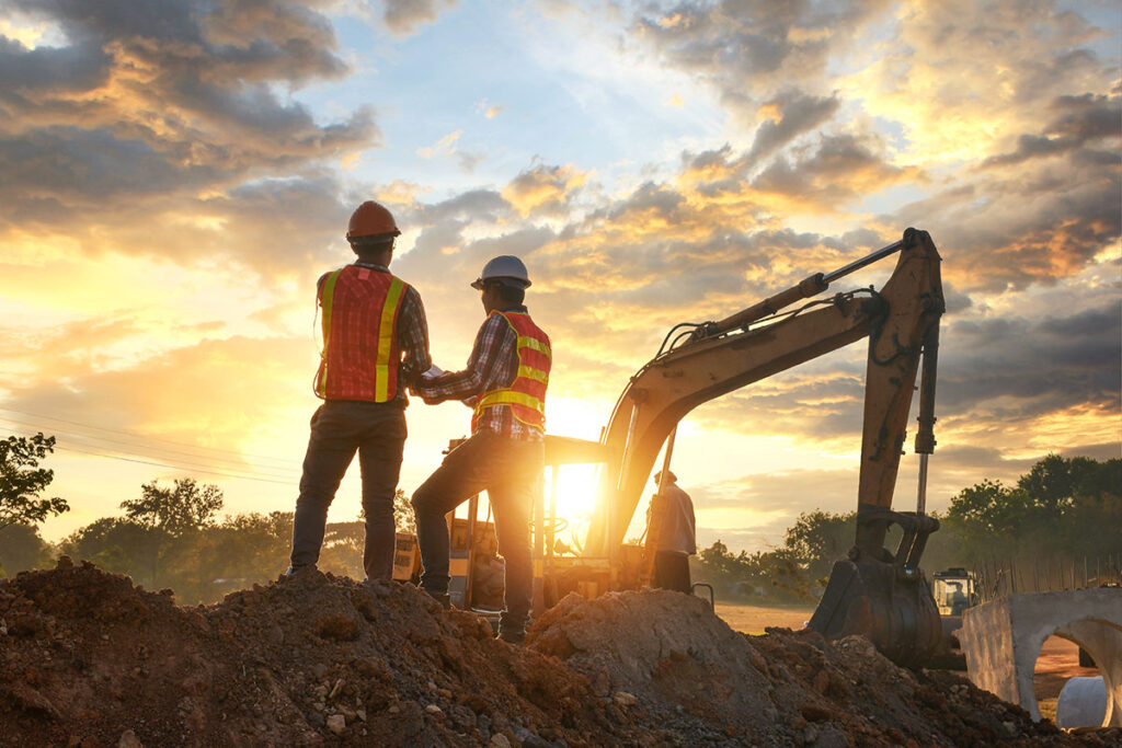 Two construction engineers supervise the excavation process of wine cave construction.