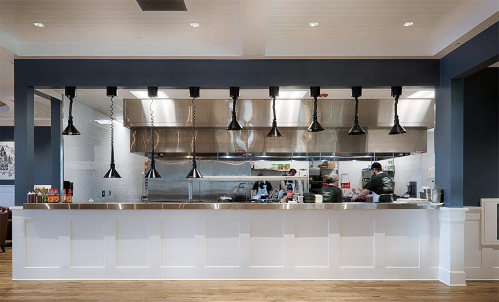 Chefs cooking in a modern commercial kitchen with blue walls