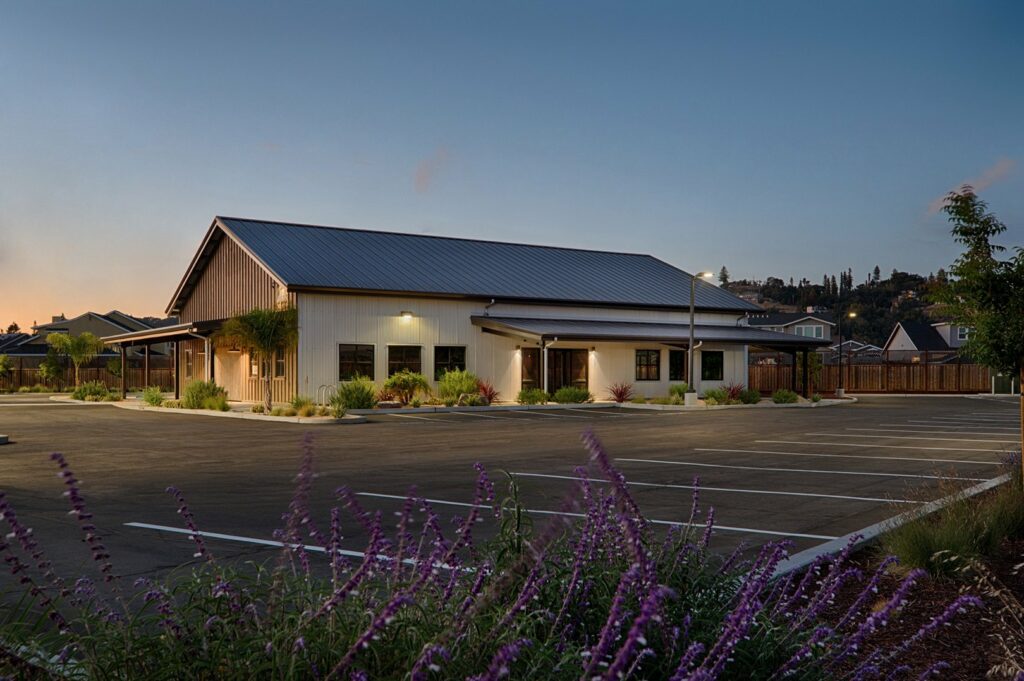 A modern pre-engineered metal building with a spacious parking lot