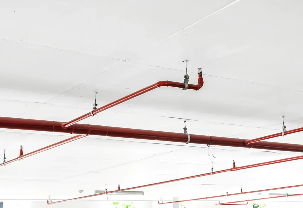 A fire suppression system on the ceiling of a commercial building, showing the concept of active fire protection (